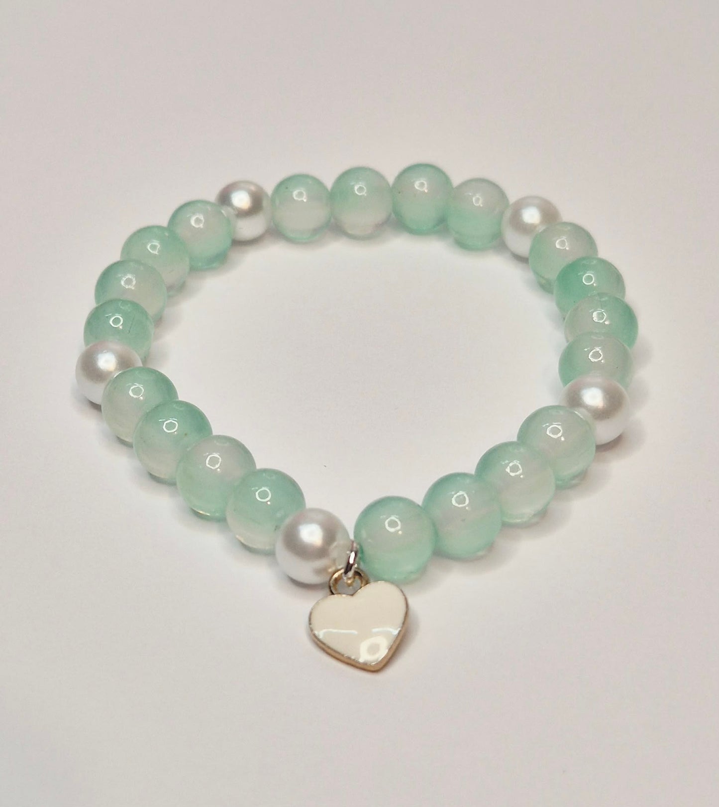 Green and white glass bead bracelet with a white heart charm