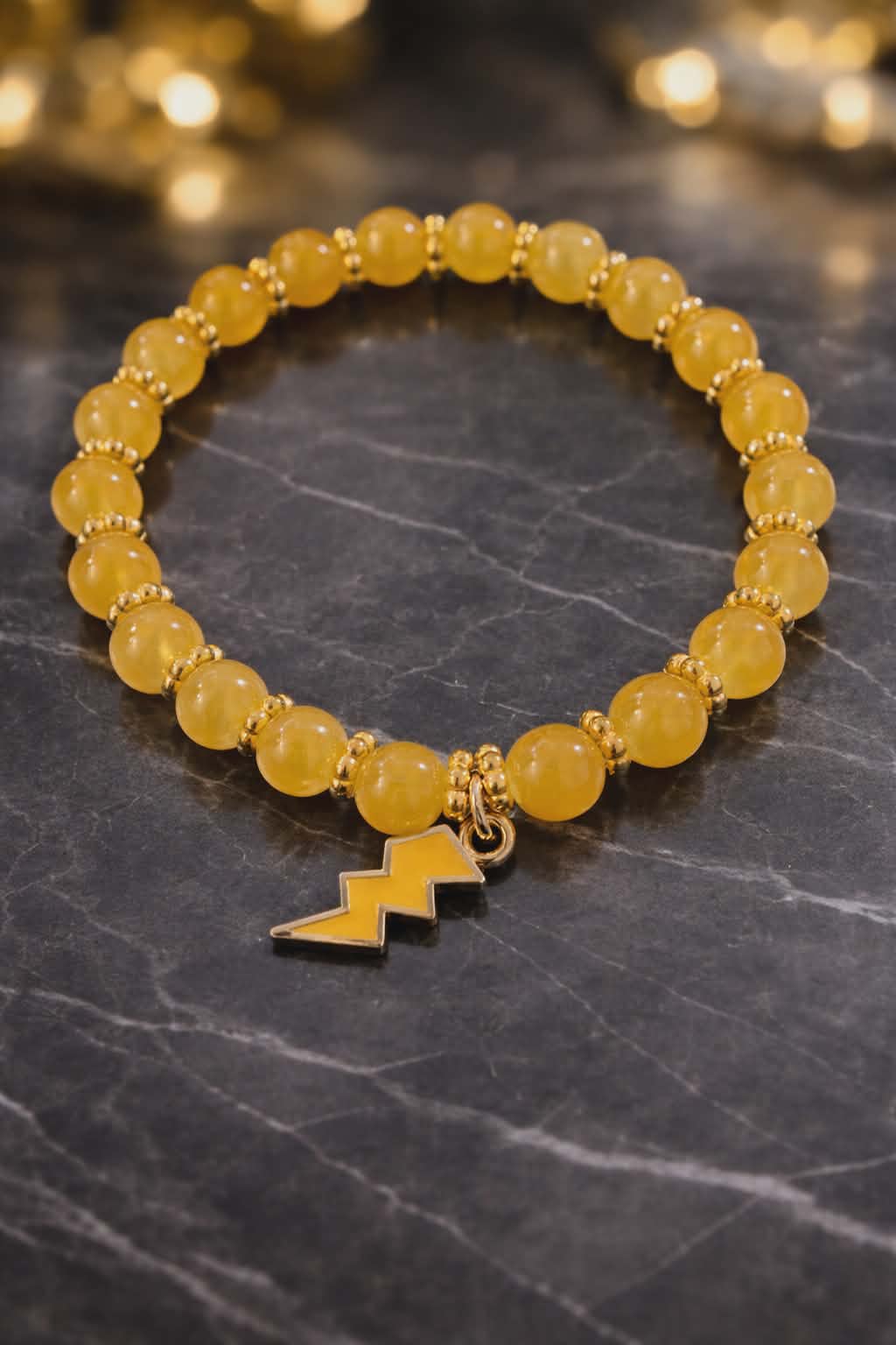 Yellow glass bead bracelet with gold spacers and yellow lightening charm