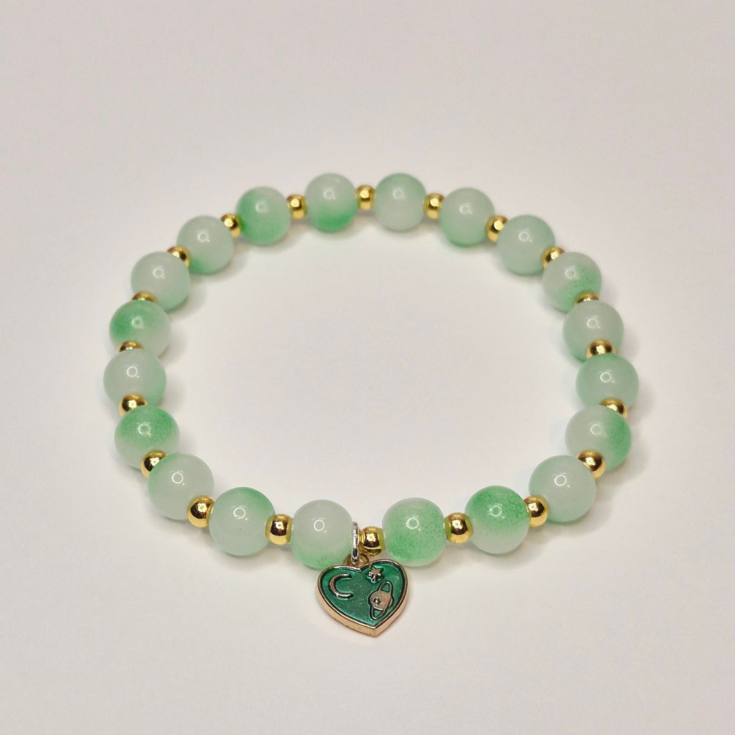 Green glass bead bracelet with gold spacers and green heart charm