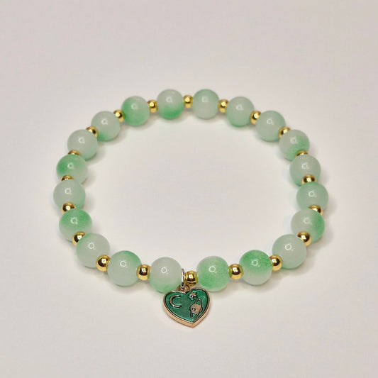Green glass bead bracelet with gold spacers and green heart charm