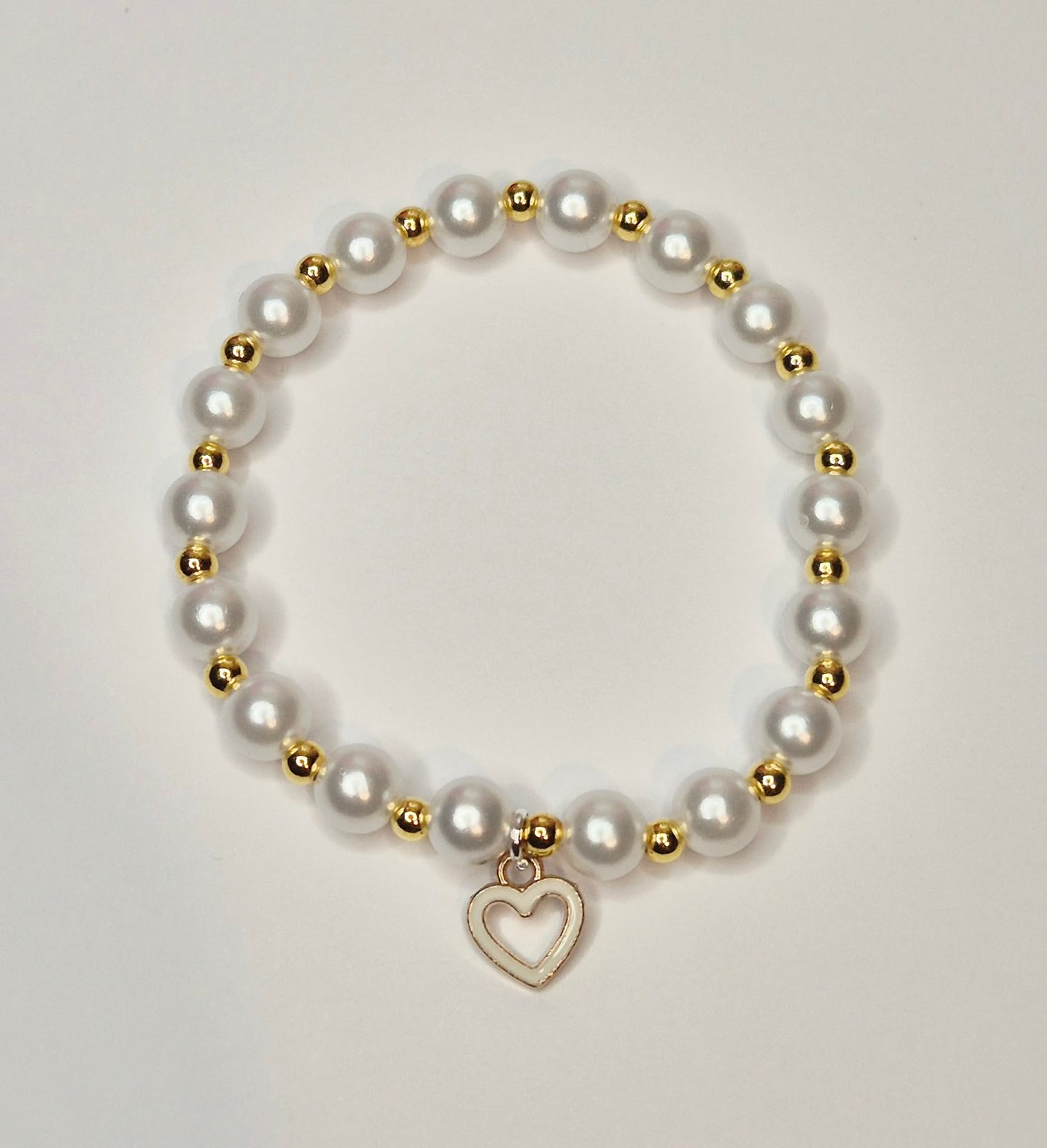 White glass bead bracelet with gold spacers and a white heart charm